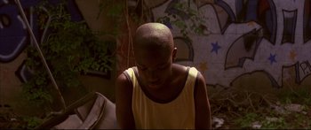 Movie still from “George Washington” (2000), directed by David Gordon Green – A young man with a shaved head is looking down; Close Up shot, High angle