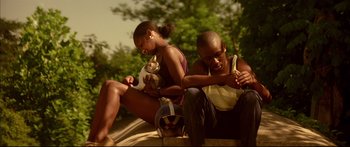 Movie still from “George Washington” (2000), directed by David Gordon Green – A man and a woman sitting next to each other on the ground; Medium shot, Low angle