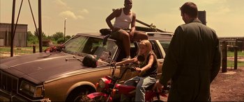 Movie still from “George Washington” (2000), directed by David Gordon Green – A man and a woman sitting on the hood of a car; Wide shot, Low angle