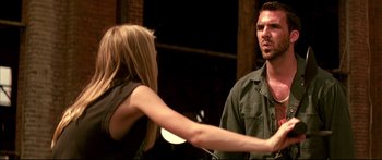 Movie still from “George Washington” (2000), directed by David Gordon Green – A man and a woman are holding hands in front of a brick wall; Medium shot, Over the shoulder angle
