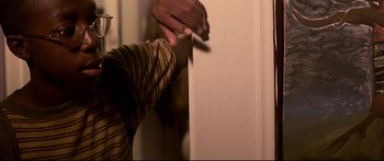 Movie still from “George Washington” (2000), directed by David Gordon Green – A person holding a piece of paper near a wall; Close Up shot, Low angle