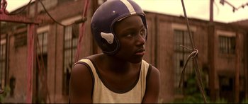 A young man wearing a football helmet and looking to his left