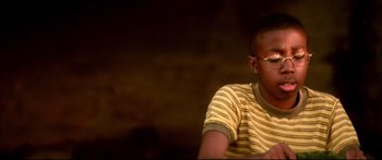Movie still from “George Washington” (2000), directed by David Gordon Green – A young man sitting in front of a brick wall; Close Up shot, High angle