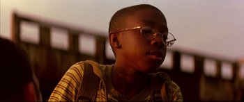 Movie still from “George Washington” (2000), directed by David Gordon Green – A young boy wearing glasses and wearing a backpack; Close Up shot, Low angle