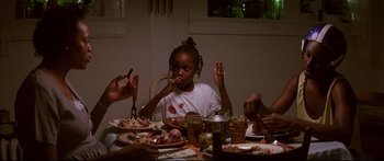Movie still from “George Washington” (2000), directed by David Gordon Green – A group of people sitting around a table eating food; Medium shot, High angle