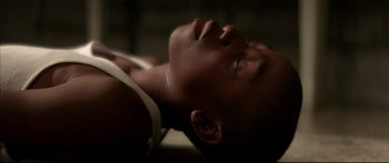 Movie still from “George Washington” (2000), directed by David Gordon Green – A person laying on the ground with their eyes closed; Close Up shot, Overhead angle