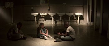 Movie still from “George Washington” (2000), directed by David Gordon Green – A man and a woman sitting on the ground in a bathroom; Wide shot, High angle