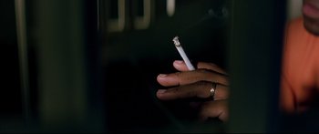 Movie still from “George Washington” (2000), directed by David Gordon Green – A person holding a cigarette in their hands; Extreme Close Up shot, Overhead angle