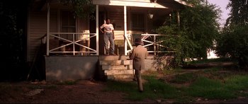 Movie still from “George Washington” (2000), directed by David Gordon Green – Two men standing on the front steps of a house; Wide shot, Over the shoulder angle