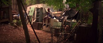 Movie still from “George Washington” (2000), directed by David Gordon Green – A man sitting on top of a pile of garbage; Wide shot, High angle