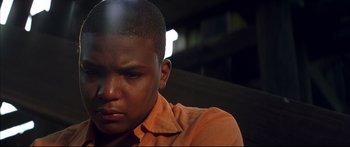 Movie still from “George Washington” (2000), directed by David Gordon Green – A man in an orange shirt is looking down; Close Up shot, Low angle