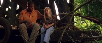 Movie still from “George Washington” (2000), directed by David Gordon Green – A man and a woman sitting on a tree branch; Medium shot, Low angle