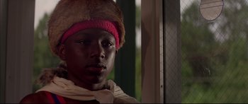 Movie still from “George Washington” (2000), directed by David Gordon Green – A young man wearing a pink headband and a fur hat; Close Up shot, Low angle