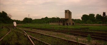 Movie still from “George Washington” (2000), directed by David Gordon Green – An abandoned building sitting on the side of a train track; Extreme Wide shot, High angle