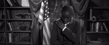 Movie still from “George Washington” (2000), directed by David Gordon Green – A black and white photo of a man in a suit; Medium shot, Low angle