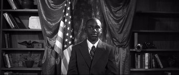 Movie still from “George Washington” (2000), directed by David Gordon Green – A black and white photo of a man in a suit and tie; Medium shot, Low angle
