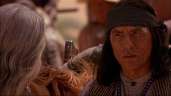 Movie still from “Geronimo: An American Legend” (1993), directed by Walter Hill – A man with long black hair is getting his hair combed; Close Up shot, Over the shoulder angle