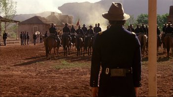 Movie still from “Geronimo: An American Legend” (1993), directed by Walter Hill – A group of men on horses in a field; Wide shot, Over the shoulder angle