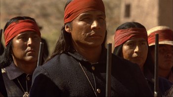 Movie still from “Geronimo: An American Legend” (1993), directed by Walter Hill – A group of people with long hair and red bandanas; Close Up shot, Over the shoulder angle