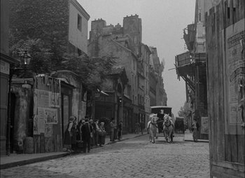 Movie still from “Gervaise” (1956), directed by René Clément – An old photo of a horse and carriage on a street; Extreme Wide shot, High angle