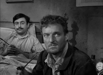 Movie still from “Gervaise” (1956), directed by René Clément – Two men sitting in front of each other in a room; Close Up shot, Over the shoulder angle