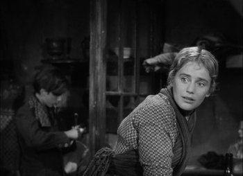 Movie still from “Gervaise” (1956), directed by René Clément – A woman in a plaid jacket and a boy in a plaid jacket; Medium shot, Over the shoulder angle