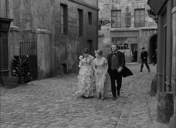 Movie still from “Gervaise” (1956), directed by René Clément – A man and a woman walking down a street; Wide shot, High angle