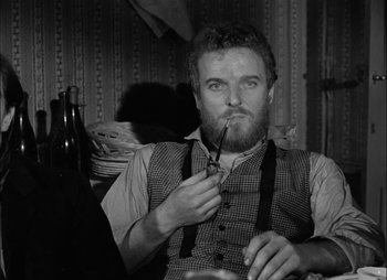 Movie still from “Gervaise” (1956), directed by René Clément – A man with a goatee holding a pair of scissors; Close Up shot, Over the shoulder angle