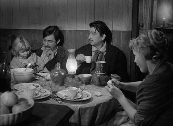 Movie still from “Gervaise” (1956), directed by René Clément – A group of people sitting around a table; Medium shot, High angle