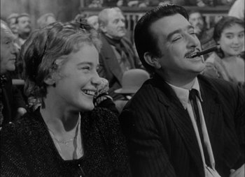 Movie still from “Gervaise” (1956), directed by René Clément – A man and a woman sitting next to each other in front of an audience; Medium shot, Low angle