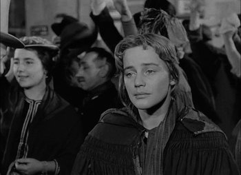 Movie still from “Gervaise” (1956), directed by René Clément – A black - and - white photo of a woman in a crowd; Close Up shot, Over the shoulder angle
