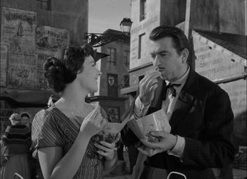 Movie still from “Gervaise” (1956), directed by René Clément – A man and a woman are sharing a bite of food; Medium shot, High angle