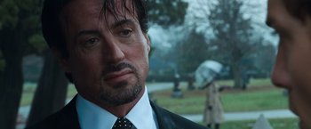 Movie still from “Get Carter” (2000), directed by Stephen Kay – A person wearing a suit and tie; Close Up shot, Over the shoulder angle