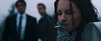 Movie still from “Get Carter” (2000), directed by Stephen Kay – A woman is smoking a cigarette while wearing a scarf; Close Up shot, Over the shoulder angle