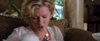Movie still from “Get Carter” (2000), directed by Stephen Kay – A woman is lighting a cigarette on a couch; Close Up shot, Low angle