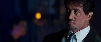 Movie still from “Get Carter” (2000), directed by Stephen Kay – A person wearing a suit and tie; Close Up shot, Over the shoulder angle