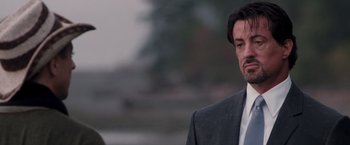 Movie still from “Get Carter” (2000), directed by Stephen Kay – A person wearing a suit and tie; Close Up shot, Over the shoulder angle