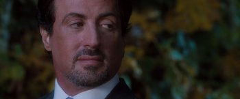 Movie still from “Get Carter” (2000), directed by Stephen Kay – A person wearing a suit and tie; Close Up shot, Over the shoulder angle