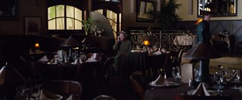 Movie still from “Get Carter” (2000), directed by Stephen Kay – A man sitting at a table in front of a plate of food; Wide shot, High angle