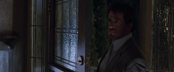 Movie still from “Get Carter” (2000), directed by Stephen Kay – A man standing in front of an open door; Close Up shot, Over the shoulder angle