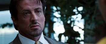 Movie still from “Get Carter” (2000), directed by Stephen Kay – A person wearing a suit and tie; Close Up shot, Over the shoulder angle