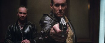 Movie still from “Get Carter” (2000), directed by Stephen Kay – A man in a leather jacket is holding a gun; Close Up shot, Low angle