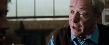 Movie still from “Get Carter” (2000), directed by Stephen Kay – An older man wearing a blue shirt and a brown vest; Close Up shot, Over the shoulder angle