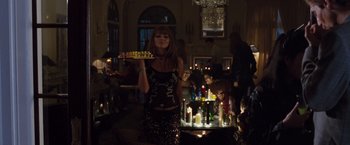 Movie still from “Get Carter” (2000), directed by Stephen Kay – A woman holding a tray with candles on top of it; Wide shot, Low angle