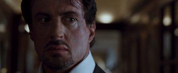 Movie still from “Get Carter” (2000), directed by Stephen Kay – A person wearing a suit and tie; Close Up shot, Over the shoulder angle