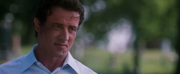 Movie still from “Get Carter” (2000), directed by Stephen Kay – A man in a white shirt is looking at the camera; Close Up shot, Over the shoulder angle