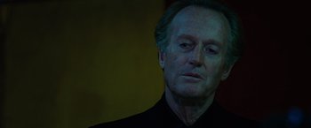 Movie still from “Ghost Rider” (2007), directed by Mark Steven Johnson – An older man in a black shirt is looking at the camera; Close Up shot, Low angle