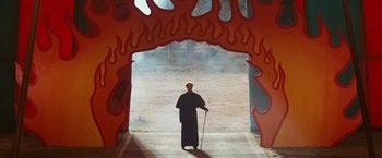 Movie still from “Ghost Rider” (2007), directed by Mark Steven Johnson – A man standing in front of a red fire arch; Wide shot, High angle
