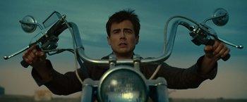 Movie still from “Ghost Rider” (2007), directed by Mark Steven Johnson – A man sitting on a motorcycle in the middle of the day; Close Up shot, Low angle