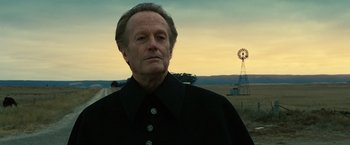 Movie still from “Ghost Rider” (2007), directed by Mark Steven Johnson – An older man standing in front of a windmill; Close Up shot, Low angle